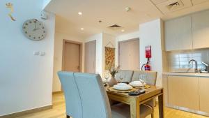 a kitchen and dining room with a table and a clock at 1BR Apartment in Yas Island with Private Balcony in Abu Dhabi