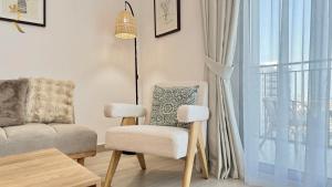 a living room with a chair and a couch and a window at 1BR Apartment in Yas Island with Private Balcony in Abu Dhabi