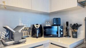 a kitchen counter with a coffee maker and a microwave at 1BR Apartment in Yas Island with Private Balcony in Abu Dhabi