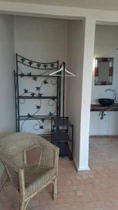 Habitación con silla, estante y lavamanos en Villa Coriandre, en Essaouira