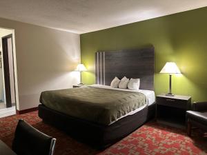 a hotel room with a bed with green walls at Hotel Inn Milwaukee in Milwaukee