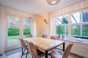 Un comedor con mesa y sillas de madera. en Villapark Kamperfoelie 89, en De Koog