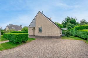 una casa con una entrada de ladrillo delante de ella en Villapark Kamperfoelie 89, en De Koog