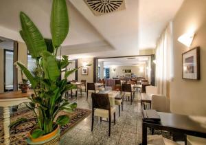 ein Restaurant mit Tischen und Stühlen und einer Pflanze in der Unterkunft Hotel Comtur in Binasco