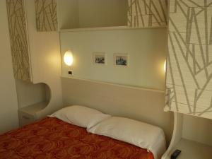 a small room with a bed and a window at Hotel Haarlem in Rimini