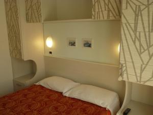 リミニにあるHotel Haarlemのベッドと窓が備わる小さな客室です。
