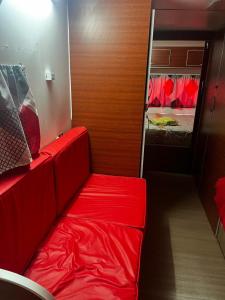 a red couch in a room with a bedroom at Bungalow Sobre Ruedas Viento Potro in San Miguel del Monte