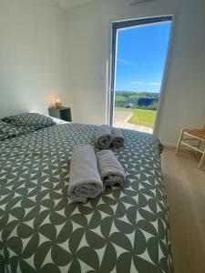 Un dormitorio con una cama con toallas. en Maison neuve vue panoramique sur la mer 6 pers à Crozon, en Crozon