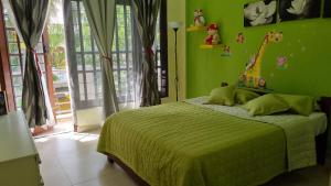 a bedroom with a bed with a green wall at Wis Villa in Galle