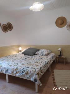 1 cama en un dormitorio con una pared blanca en Maison paisible Le Dali, en Piolenc 27 fotos más