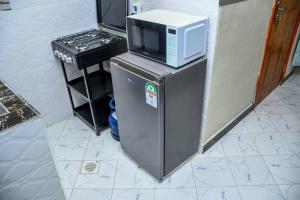 a microwave sitting on top of a refrigerator at Tala Cosy Homes in Tawa