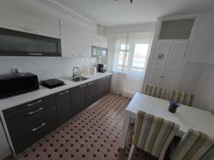 a kitchen with a sink and a table with chairs at Apartament 3 camere, zona Dedeman in Piteşti