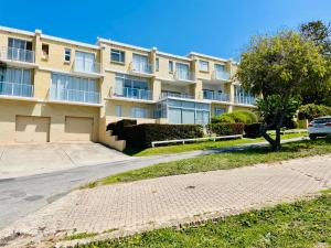 a large apartment building with a car parked in front at Panorama Sea-View Apartment in Plettenberg Bay