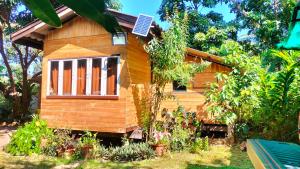 a small wooden house with a window in a yard at Bunnum Homestay in Ban Mae Tap