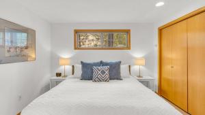 a bedroom with a large bed with two lamps at Rager Mountain - Unit 10 in Sunriver +47 photos