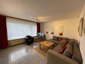 una sala de estar con un sofá y una mesa en Apartments in Westerland - Sylt 38535, en Süderende