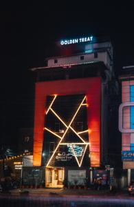 a brightly lit building with a sign on it at night at Hotel Golden Treat in Indore