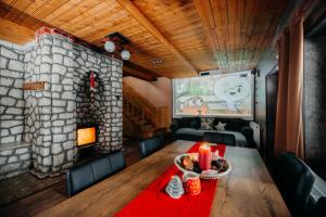 a dining room with a table and a stone fireplace at Lake House in Izvoru Mureşului