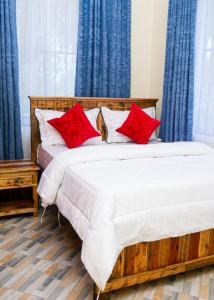 a bedroom with two beds with red pillows at VvEK B&B APARTMENT in Arusha