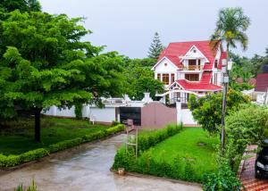a red and white house with a red roof at VvEK B&B APARTMENT in Arusha