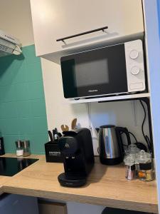 - un comptoir de cuisine avec une cafetière et un four micro-ondes dans l'établissement Le Bohème Tourisme Repos Business à Toulouse, à Toulouse