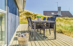 a black table and chairs on a wooden deck at Holiday Home Baunebjergvej Hvide Sande in Havrvig +18 photos