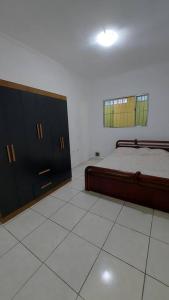 a bedroom with a bed and a cabinet in it at Casa térrea no centro ideal para famílias e trabalho in Mogi das Cruzes