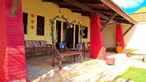 a porch of a house with red painted walls at Mar Azul Casa de Praia in Aquiraz +24 photos