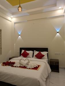 a bedroom with a large bed with red pillows at Regal Respite in Sultan Bathery