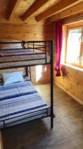 a bedroom with two bunk beds in a cabin at Chalet détente in Montaut