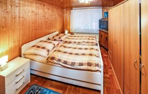 Posto letto in una piccola camera con pareti in legno. di Ferienwohnung Lassan - Wolgast a Lassan Altre 7 foto