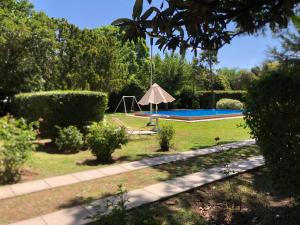 a garden with a pool and an umbrella at La Querencia in Mercedes