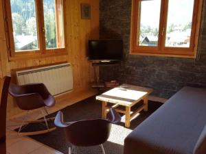 a living room with a tv and a table and chairs at Chalet de luxe 9 pers. avec cheminée, proche télécabines, Wi-Fi, équipements complets et terrasse - FR-1-676-87 in La Chapelle-dʼAbondance