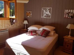 a bedroom with a large bed with pillows at Chalet de luxe 9 pers. avec cheminée, proche télécabines, Wi-Fi, équipements complets et terrasse - FR-1-676-87 in La Chapelle-dʼAbondance