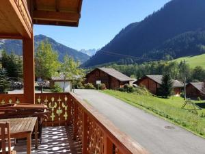 a wooden balcony with a view of a road and mountains at Chalet de luxe 9 pers. avec cheminée, proche télécabines, Wi-Fi, équipements complets et terrasse - FR-1-676-87 in La Chapelle-dʼAbondance