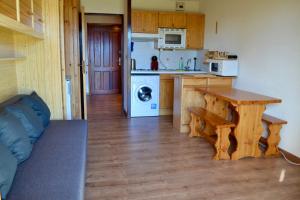 a kitchen with a table and a kitchen with a stove at Studio cabine chaleureux à Pyrénées 2000 - WiFi et parking privé in Bolquere Pyrenees 2000