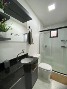 a bathroom with a toilet and a sink and a shower at Stúdio de 1 Quarto, Wifi 500mb, Condominio com Elevador, 1 Vaga de Garagem, Cozinha Completa - Indicado para Grupos, Hospedes a Trabalho, Família e Pets in Toledo