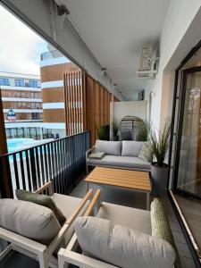a balcony with couches and a table and a couch at Baltic Waves Resort Luksusowy apartamnet z basenem i parkingiem in Międzyzdroje