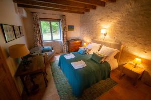 ein Schlafzimmer mit einem Bett mit einer blauen Decke in der Unterkunft Closerie de La Salière, gîte de charme et chambres d'hôtes, châteaux de la Loire, zoo de Beauval in Le Controis En Sologne + 11 Fotos