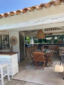 een patio met een tafel en stoelen en een keuken bij Ramatuelle, Pampelonne, villa in Saint-Tropez