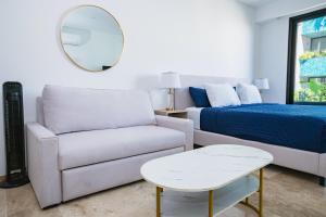 a living room with a couch and a bed and a mirror at Menesse Town Tower 202 condo in Playa del Carmen