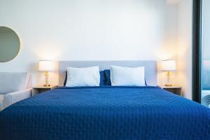 a bedroom with a blue bed with two lamps at Menesse Town Tower 202 condo in Playa del Carmen