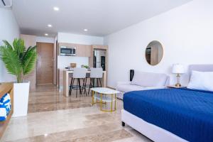 a bedroom with a bed and a living room at Menesse Town Tower 202 condo in Playa del Carmen +30 photos