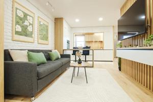 Una sala de estar con un sofá y una cocina. en Designers Apartment - chic choice for the stay, en Iaşi