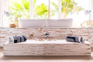 a wooden bench in front of a window with pillows at Sunrise Beach House in St Helena Bay
