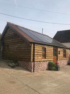a log cabin with a solar roof on it at Enchmarsh Farm Byre in Church Stretton