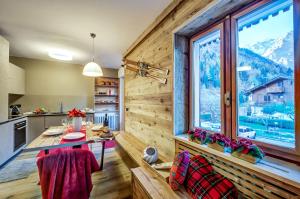 cocina con mesa y ventana grande en Casa Entreves - Ristrutturata con parcheggio, en Courmayeur