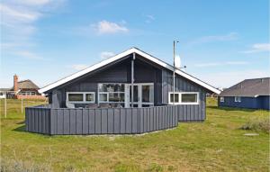 a black house in a field with grass at Holiday Home Vesterledvej Hvide Sande V in Havrvig