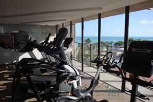 a gym with two exercise bikes in front of a balcony at ED NEW TIME 1121 Studio de Luxo à BEIRA MAR de Maceió in Maceió