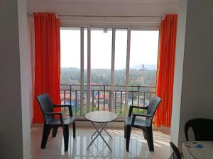 a room with a table and chairs and a large window at Zanita Heights Seaview Apartment in Bogmalo